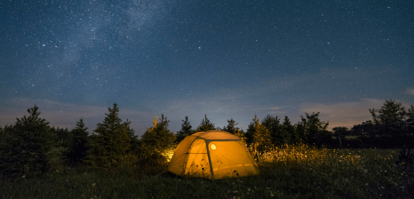 Tent in a forrest clearing at night
