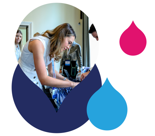navy pink and blue acquia droplets with an image of a woman picking up a badge at an acquia engage event