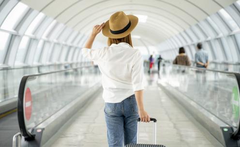 Traveler in hat with suitcase in airport