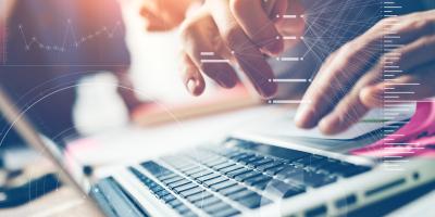 Hands on laptop keyboard with data visualizations