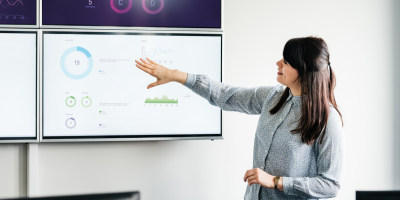 Woman facing whiteboard and explaining written information