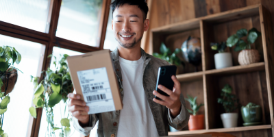 Man holding package and mobile phone
