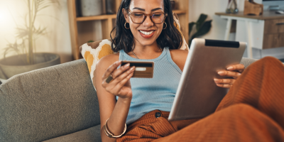 Woman reading credit card information while using a tablet