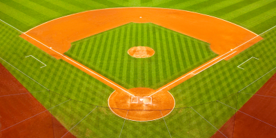 Aerial view of empty baseball diamond with bright orange bases and green grass
