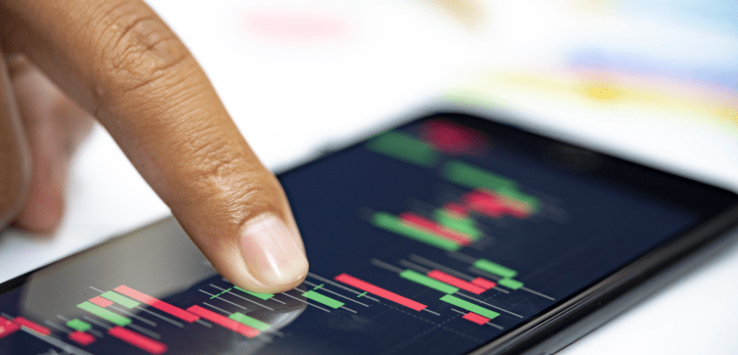 Finger touching phone screen showing stock market chart
