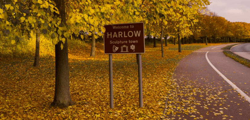 "Welcome to Harlow" highway sign with Fall foliage