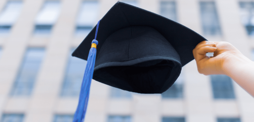 Holding a black and blue graduation cap