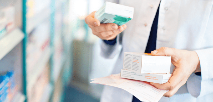 Closeup of a pharmacist holding boxes of medicine