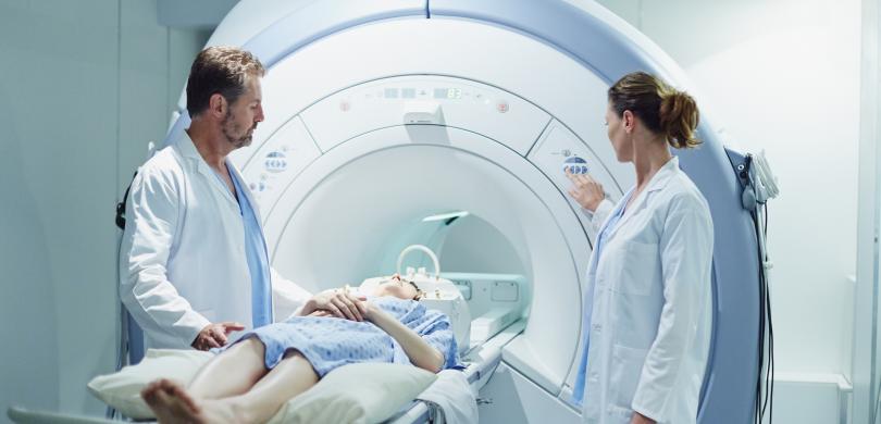 Patient on CT machine with two doctors