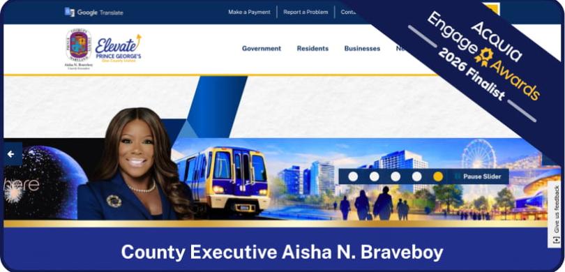 County Executive Aisha N. Braveboy speaking at podium with flags and "Prince George's County" branding