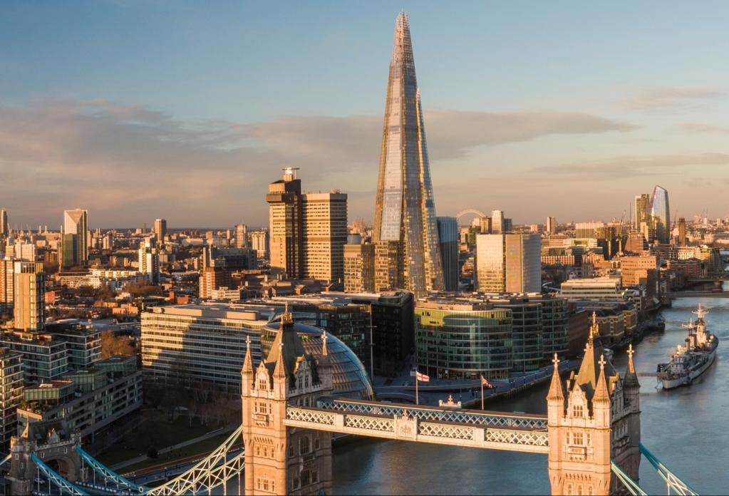 London skyline at sunset featuring Tower Bridge and The Shard skyscraper with Thames River