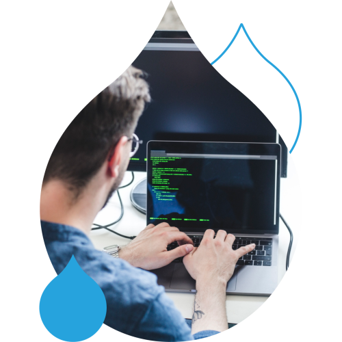 Picture of someone coding on a laptop in an acquia droplet mask