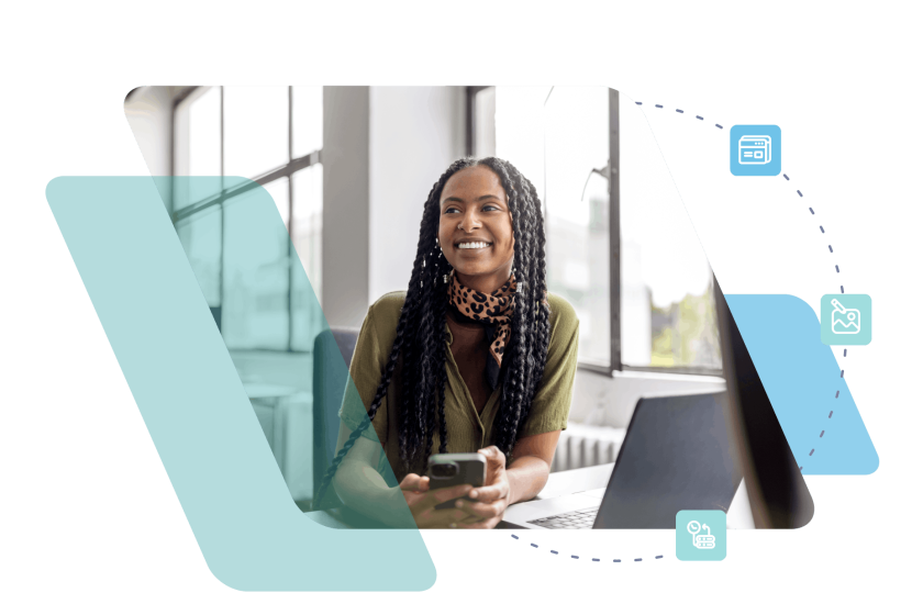 Professional woman with long dark hair smiling at desk with laptop in modern office setting