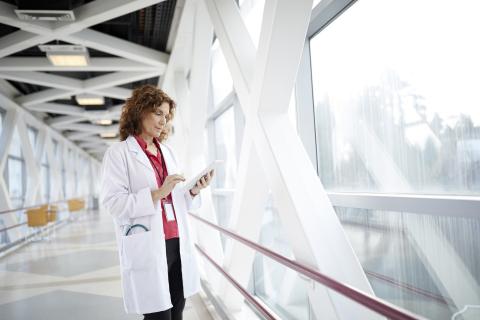 healthcare worker in front of large window 