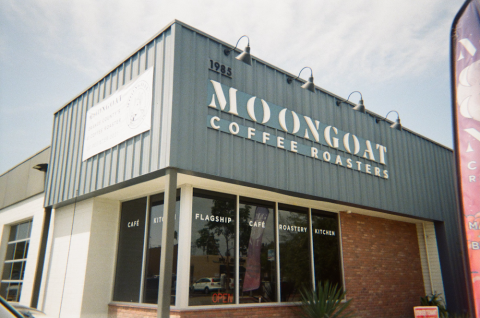 Modern storefront with "MOONSHOT" signage on a cloudy day