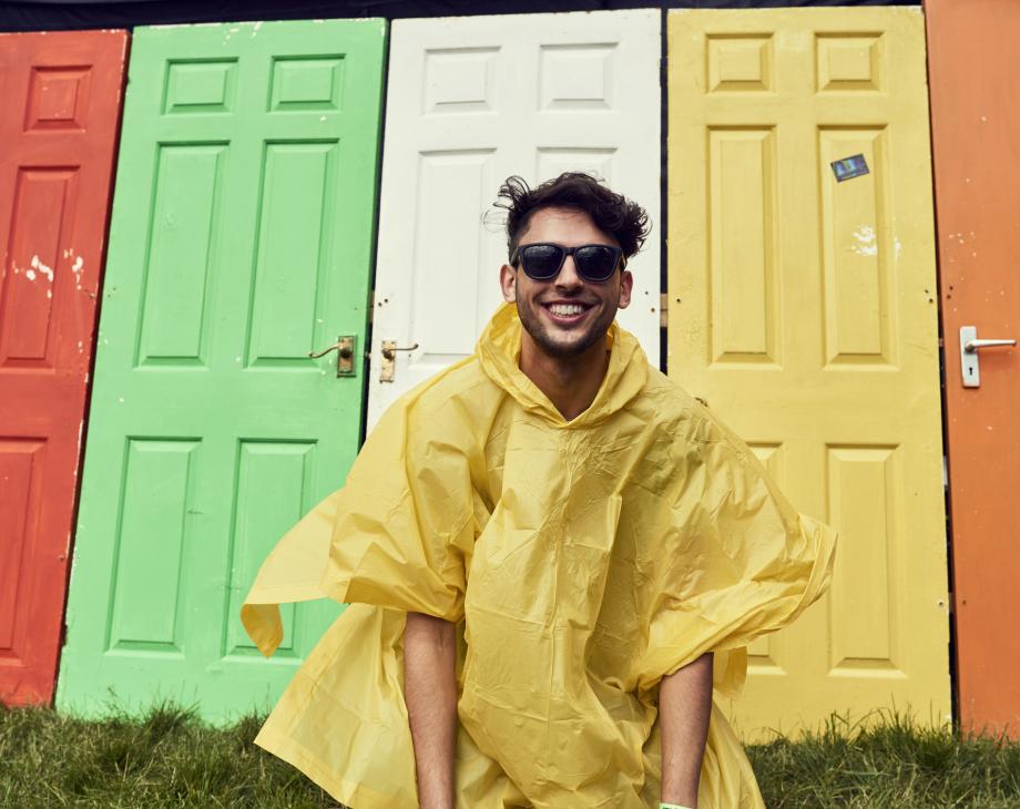 man in raincoat in front of colored doors