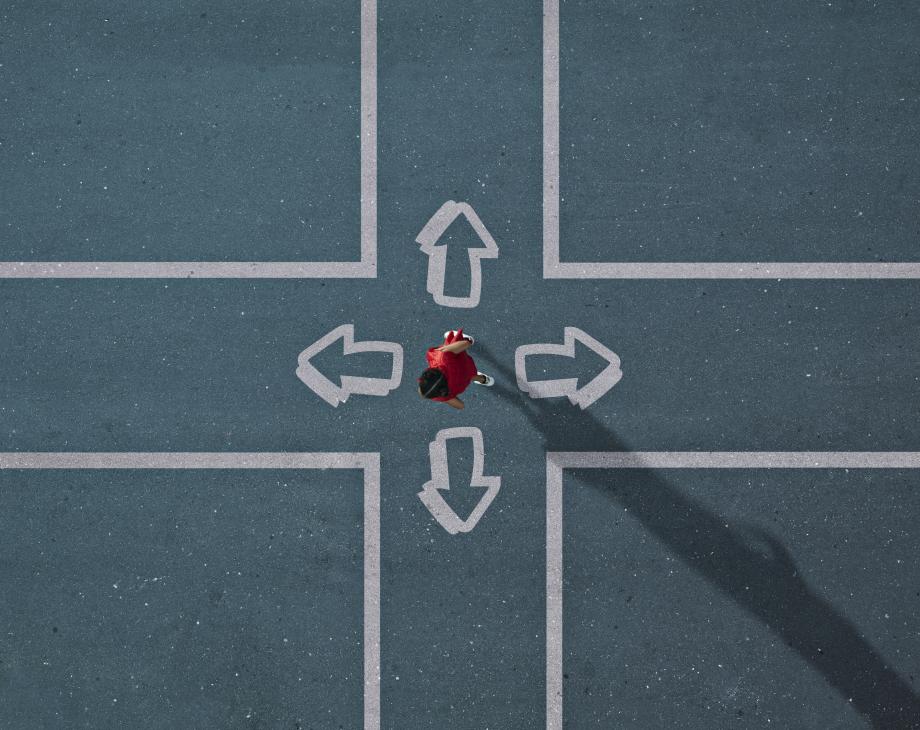 Overhead view of person at a crossroad choosing between four directions