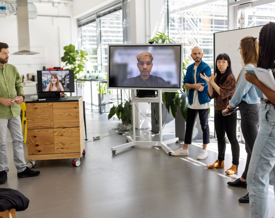 Group of people standing are screens with faces