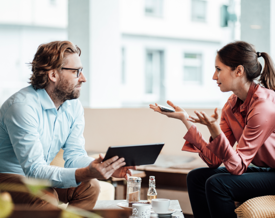 A man and woman conversing across a table 