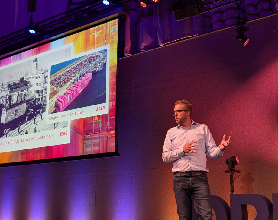Dries on stage, talking about Rotterdam and its history, and the lessons for the Drupal community