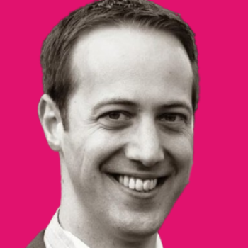 Headshot of Tom Phethean with a pink background