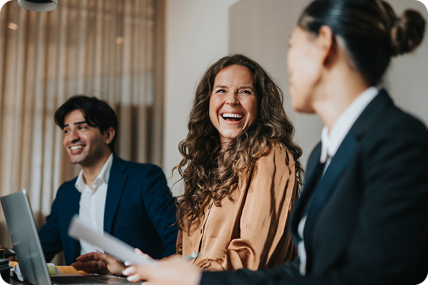 Smiling woman in business meeting with colleagues in modern office setting