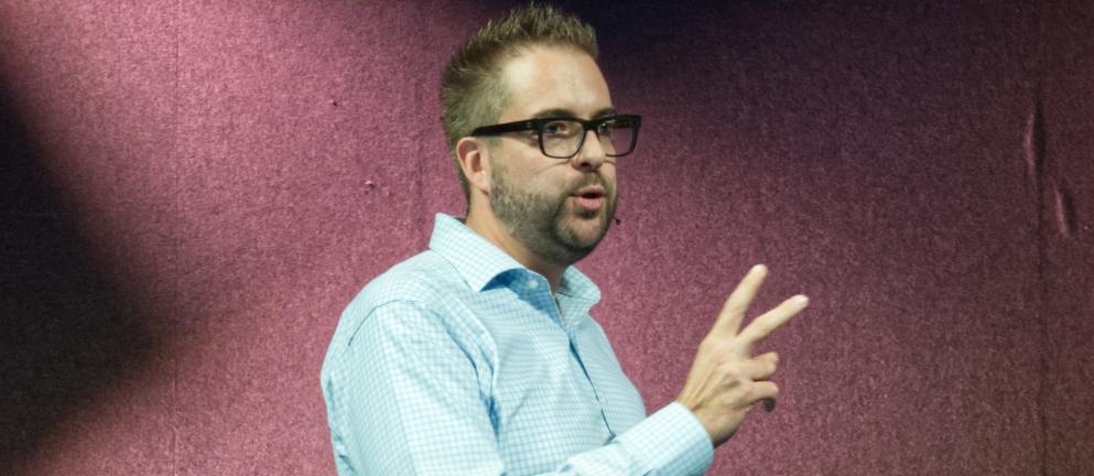 Dries on stage in Rotterdam, holding up two fingers